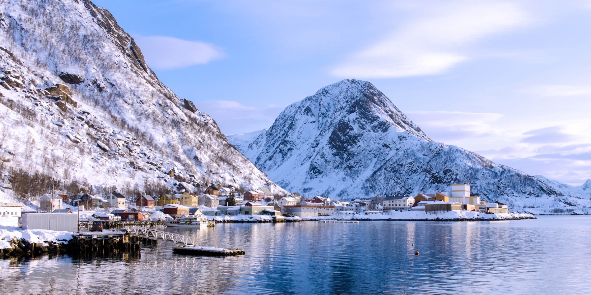 Snow-covered houses in the port of Øksfjord in Norway
