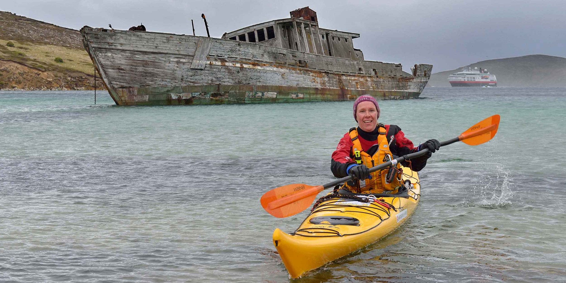 Lady in kayak in front of shipwreck