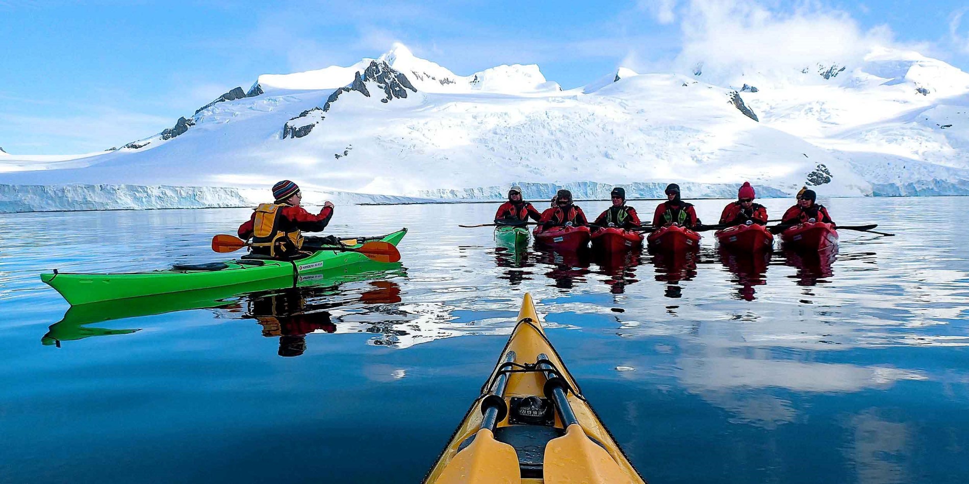 People in kayaks in antarctic landscape